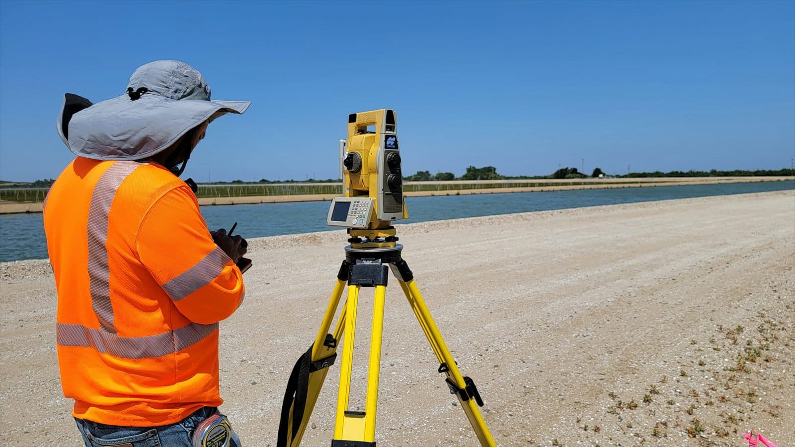 Land surveyor operating surveying equipment outdoors